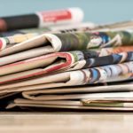 CROPPED Stack of newspapers on white wood table