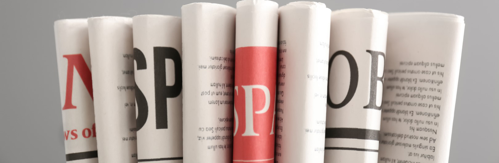 Various newspapers on grey background